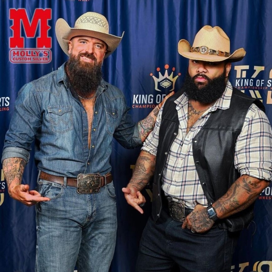 Two men with belt buckles showcasing in a rodeo event